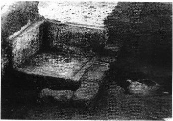 A stone bath with plastered sides and drain. Just below the outlet of the bath, water drained into a vase perforated at the bottom and cemented into the earth.
